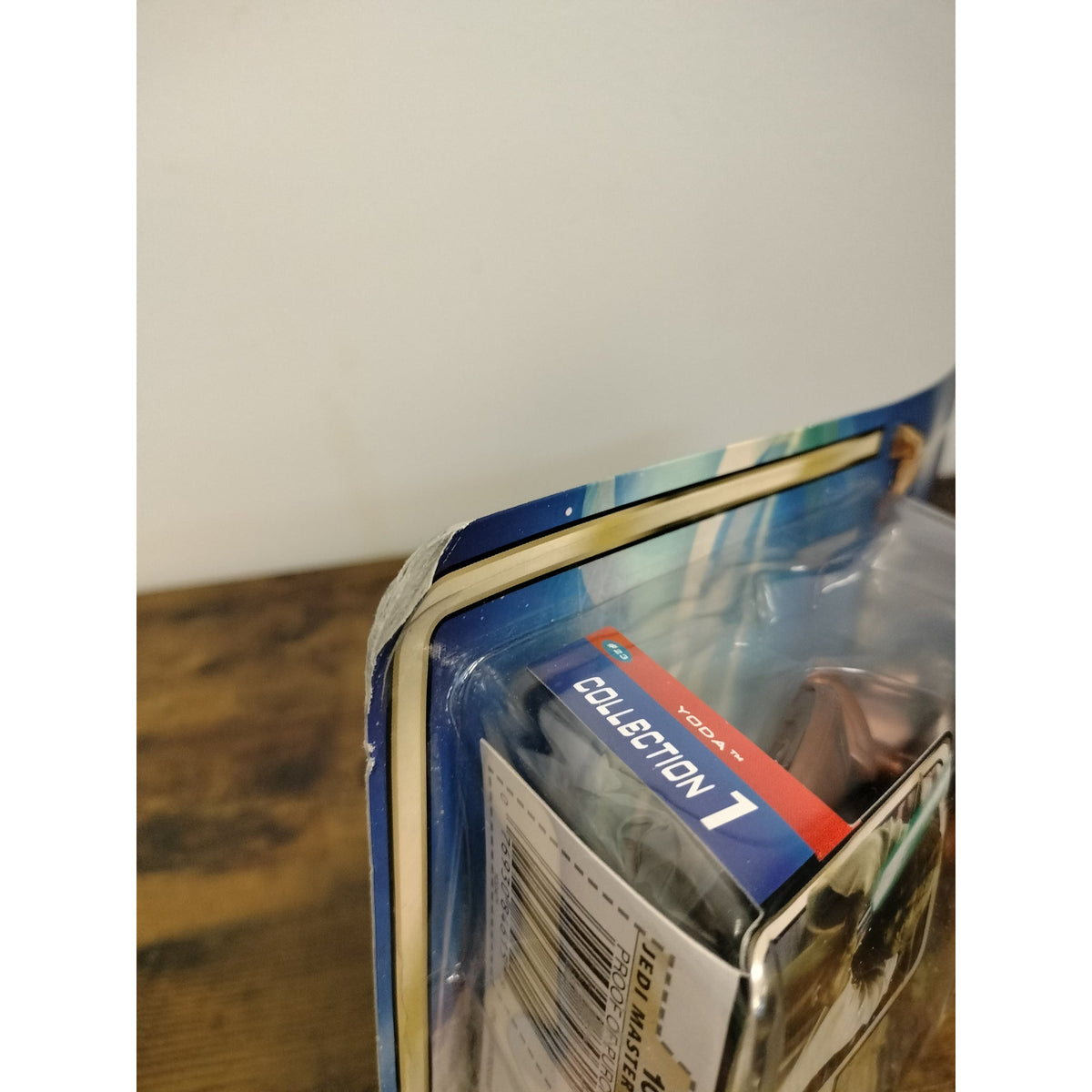 Actual item photographed: close-up of bent and worn corner on Yoda Jedi Master retail card