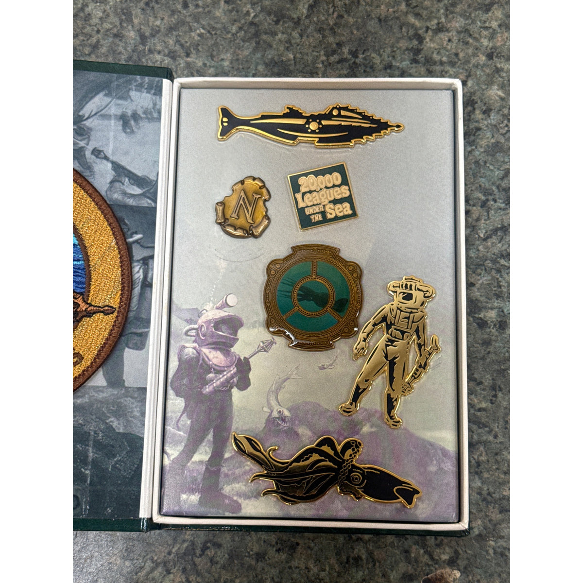 Six Disney anniversary pins in their illustrated presentation box